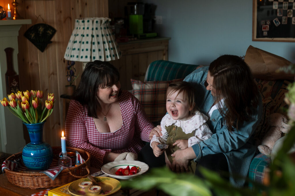 Mother and daughter having strawberries in a scotland's home of the year finalist home while natural light pours in
