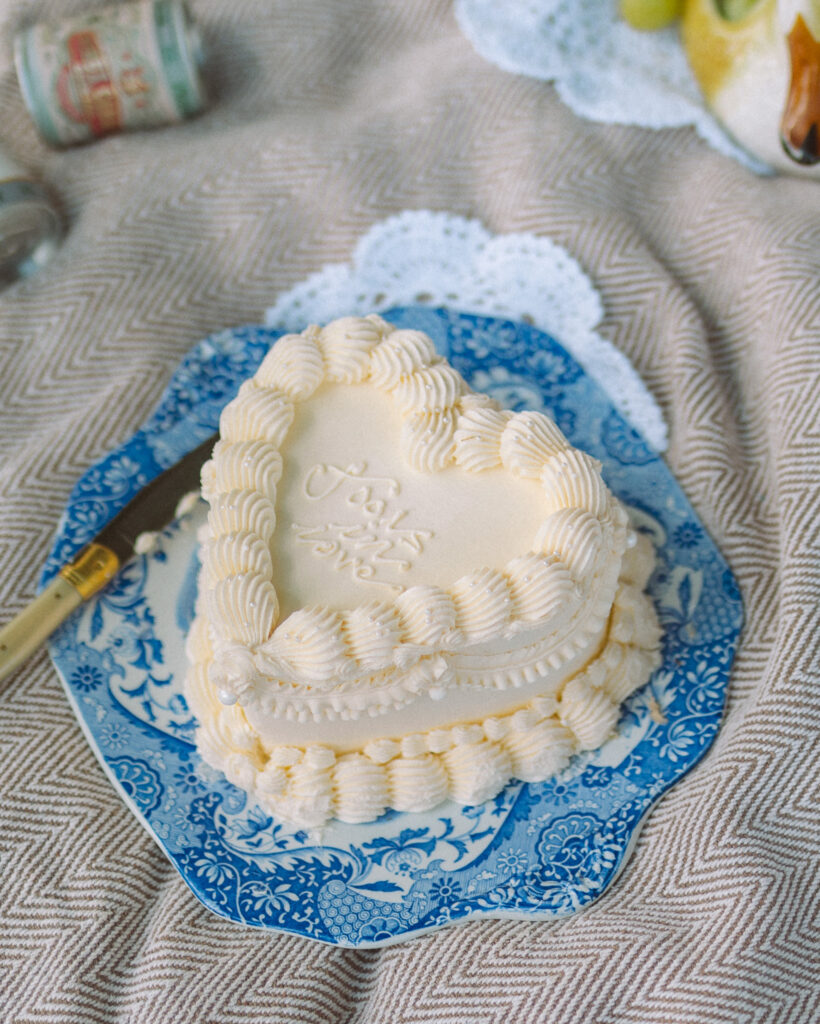 a small white heart shaped cake that reads fools in love 