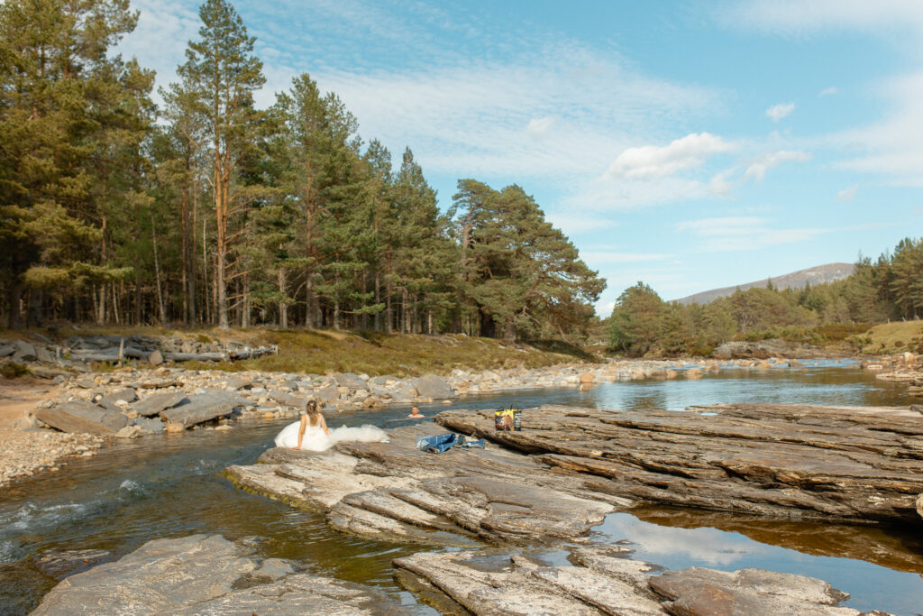 groom goes for a wild swim after their ceremony and bride watches from the rocks and basks in the sun 